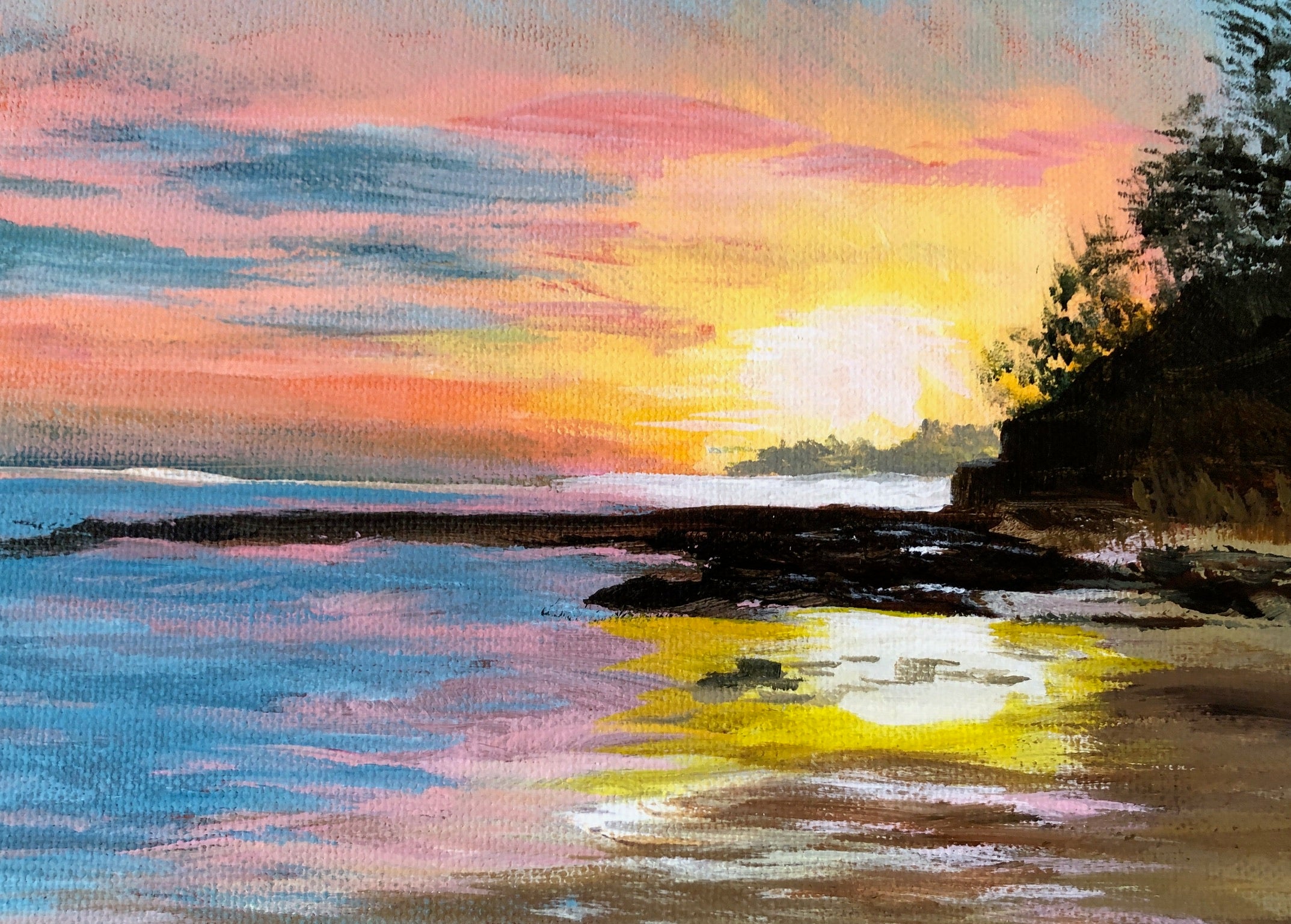 A colorful landscape painting of a beach sunset, featuring blue water, a bright yellow sun near the horizon, pink and orange clouds, and dark silhouetted trees on the right.